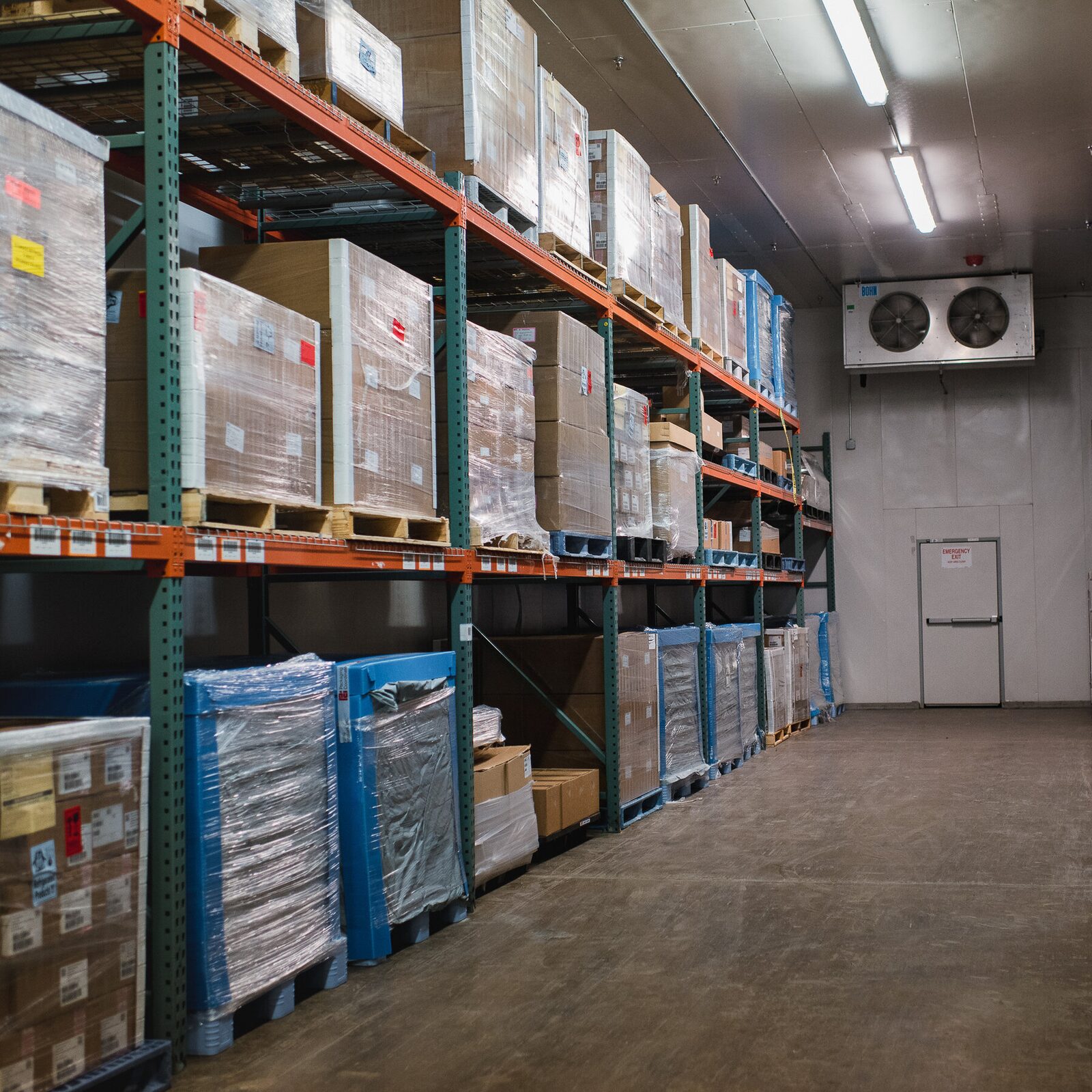 Cold-storage warehouse racking with wrapped pallets, representative of controlled storage and pharmaceutical/healthcare distribution